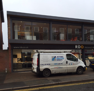 Clearing blocked drains (manhole) outside retail property in Bancroft Road, Reigate, Surrey RH2